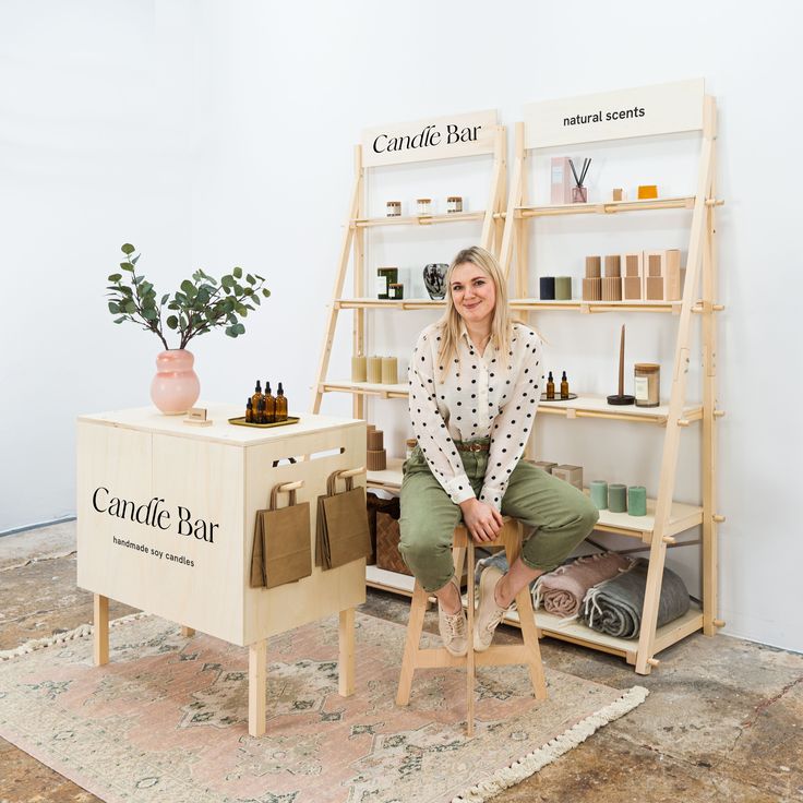 a woman is sitting on a stool in front of a counter with bottles and bags