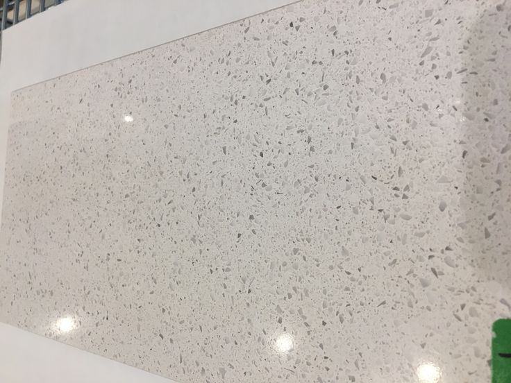 a white counter top sitting inside of a kitchen next to a green object on the floor