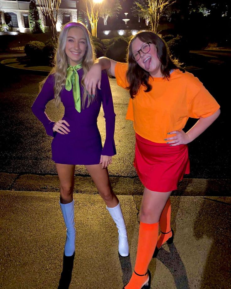 two women dressed in costumes posing for the camera