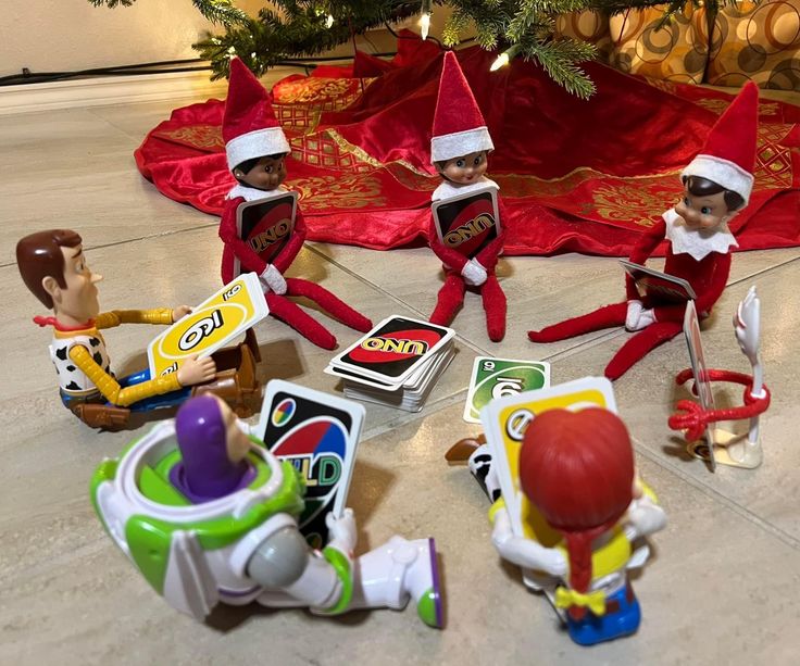 the elfs are playing with their toys under the christmas tree