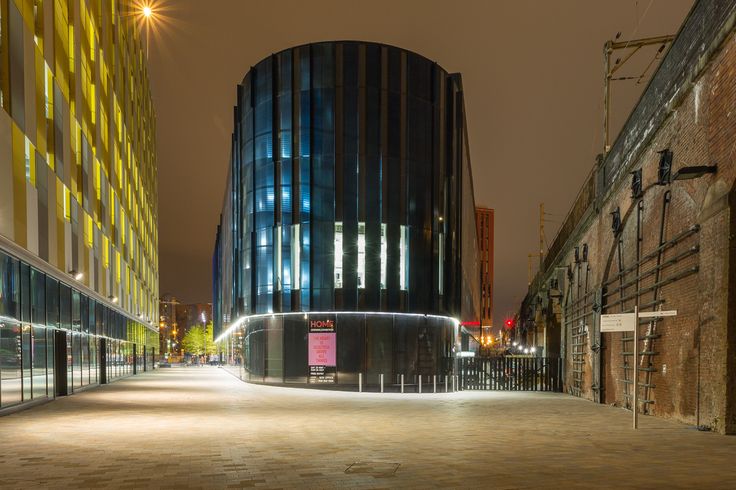 an empty city street at night with buildings in the background