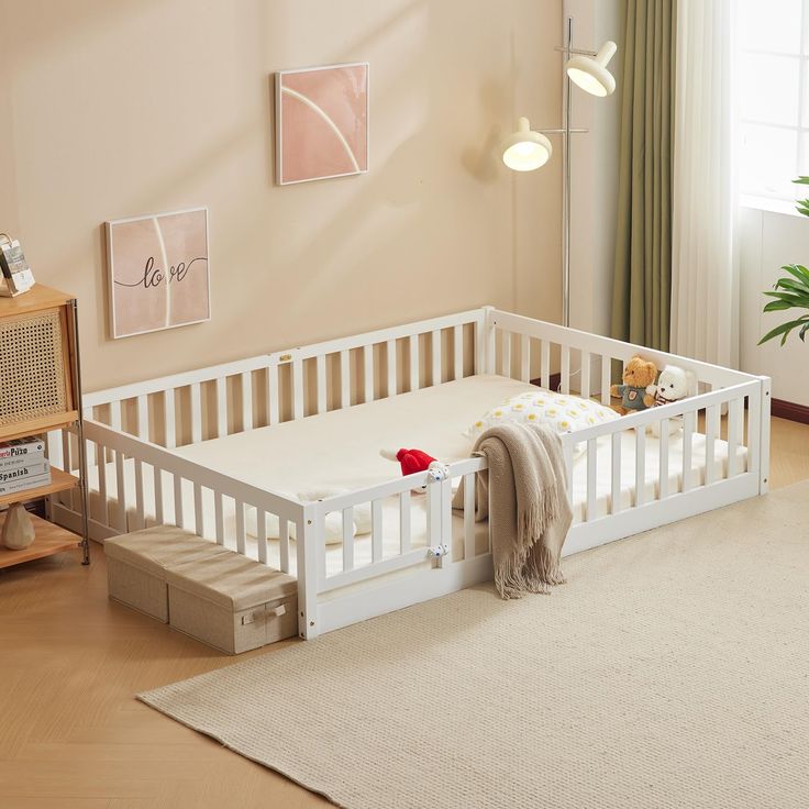 a white baby crib sitting on top of a wooden floor