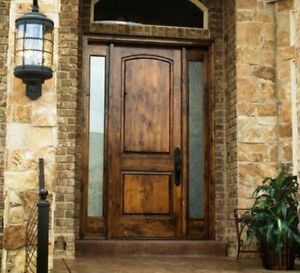 a wooden door sitting on the side of a brick building next to a lamp post