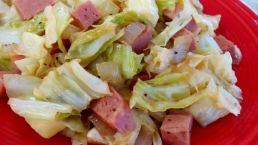 a red plate topped with lettuce and ham