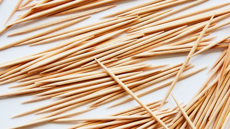 toothpicks are lined up on a white surface