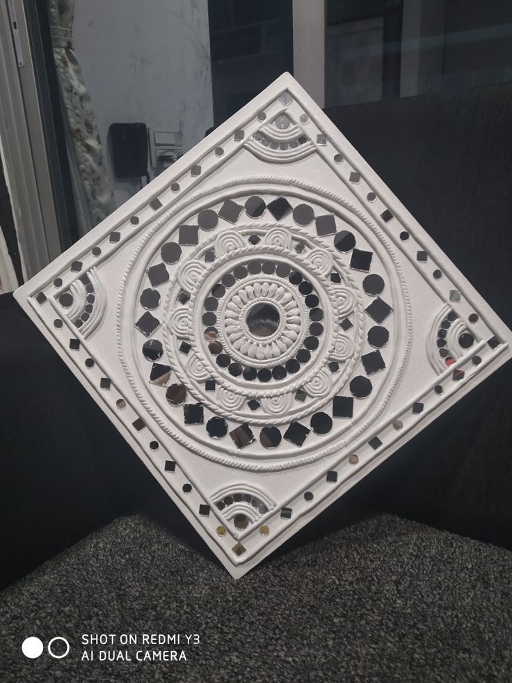 a white decorative object sitting on top of a black couch