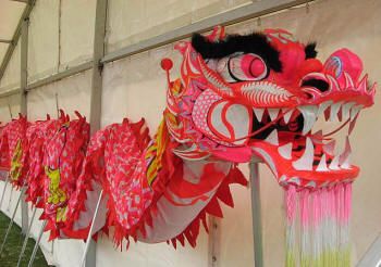 two red and pink dragon masks hanging on a wall