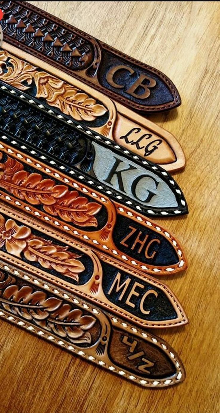 four leather name tags sitting on top of a wooden table