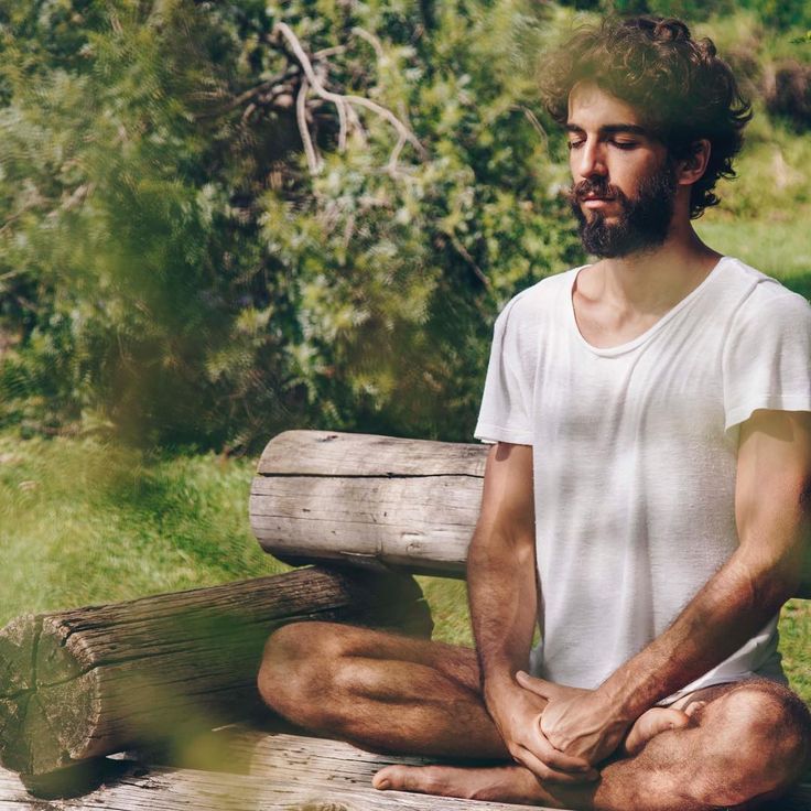 a man sitting on top of a wooden bench