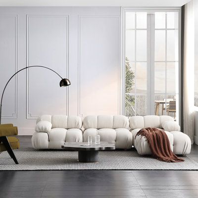 a living room with white furniture and large windows