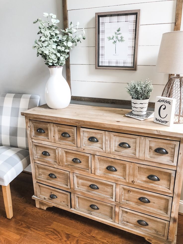 a wooden dresser with drawers and flowers on top