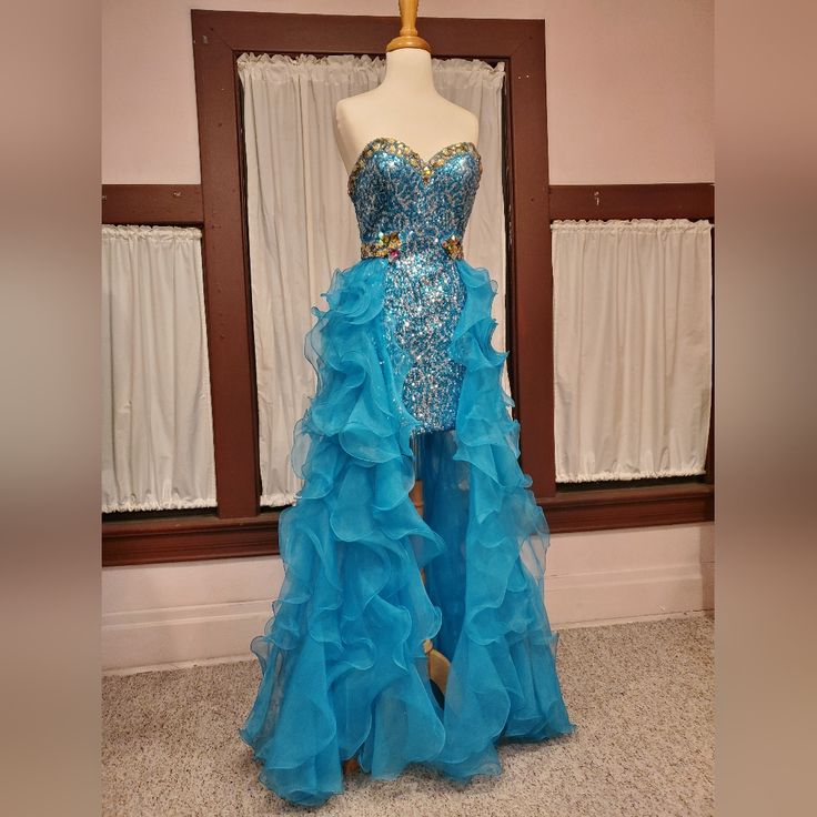 This Is Tagged A Size 4 But Fits The Size 6 Dressform. Measures: Bust 35" Waist 25.5" Hips 36" This Gown Has Not Been Worn Or Altered. It Has Been Stored Hanging & Bagged. The Beads Are Secure. All The Inside Labels Are Intact. Light Blue Ruffled Dresses For Prom Season, Light Blue Ruffled Dresses For Prom, Light Blue Ruffled Dress For Gala, Fitted Blue Evening Dress With Ruffles, Floor-length Gown With Ruffles For Pageant, Blue Ruffled Evening Dress For Gala, Blue Ruffled Skirt Dress For Prom, Fitted Ruffled Gown For Homecoming, Fitted Ruffle Gown For Homecoming