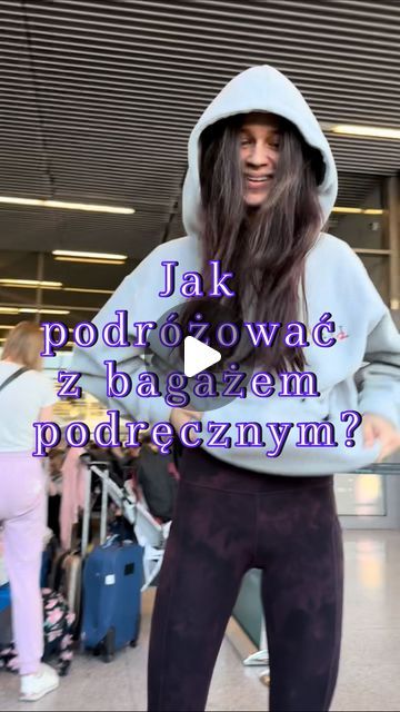 a woman with long hair wearing a hoodie and leggings in an airport