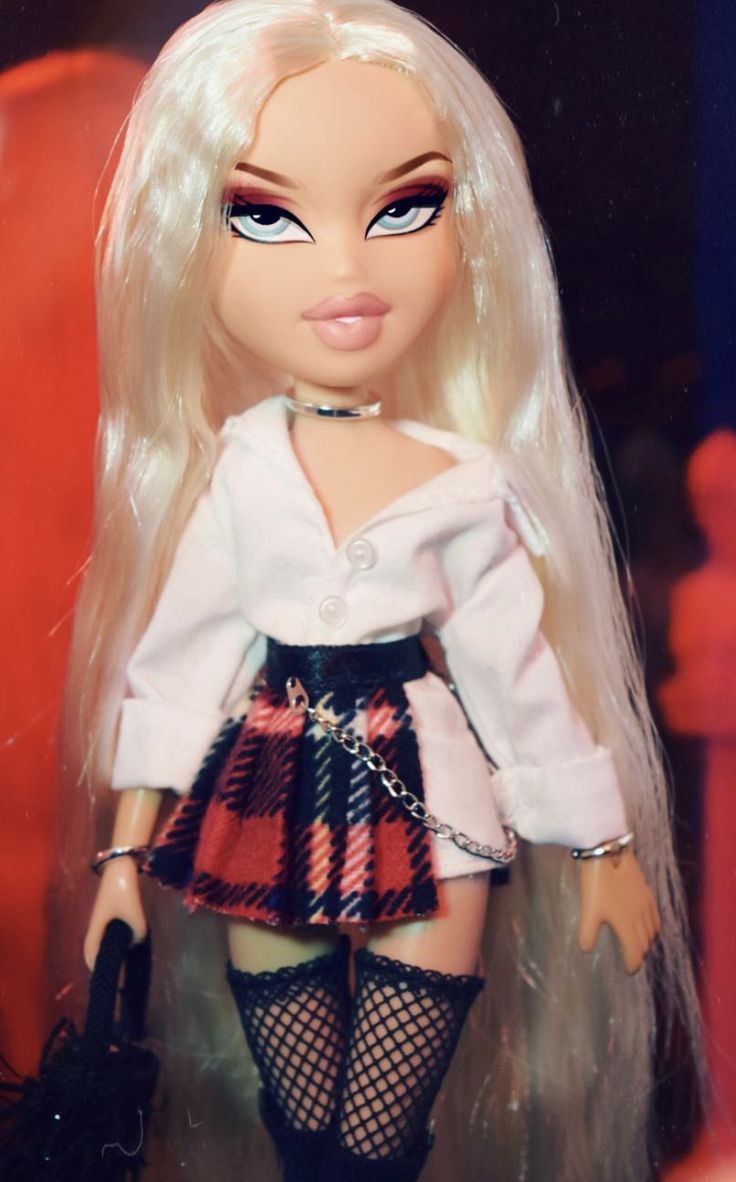 a doll with long blonde hair wearing a skirt and stockings, holding a handbag