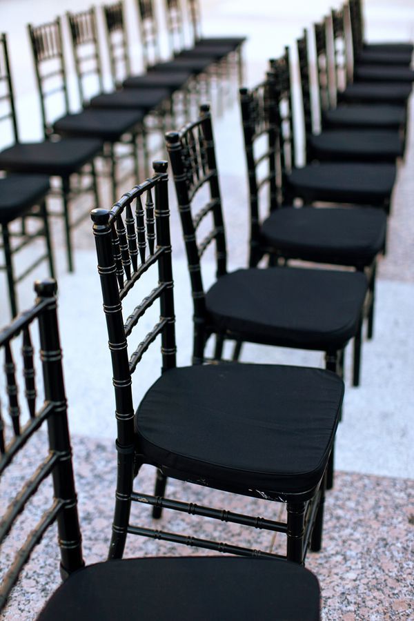 rows of black chairs lined up on the ground