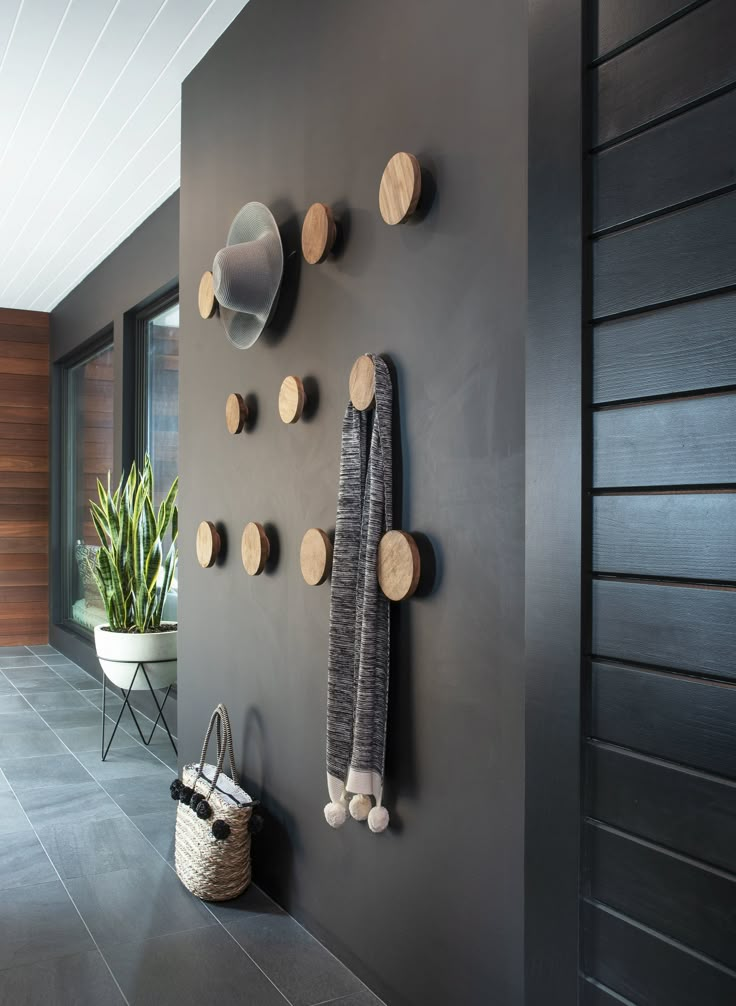 a wall with several pieces of wood hanging on it's side and a plant next to it