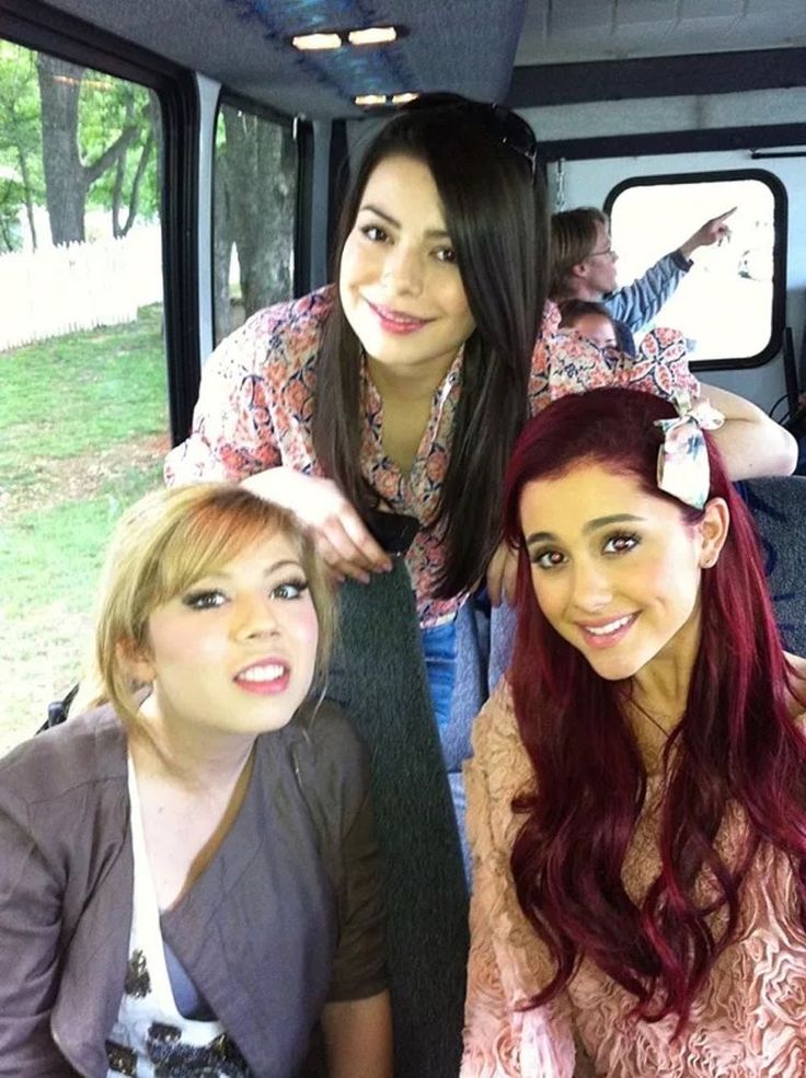 three young women sitting in the back of a bus