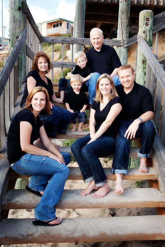 a family poses on some steps at the beach