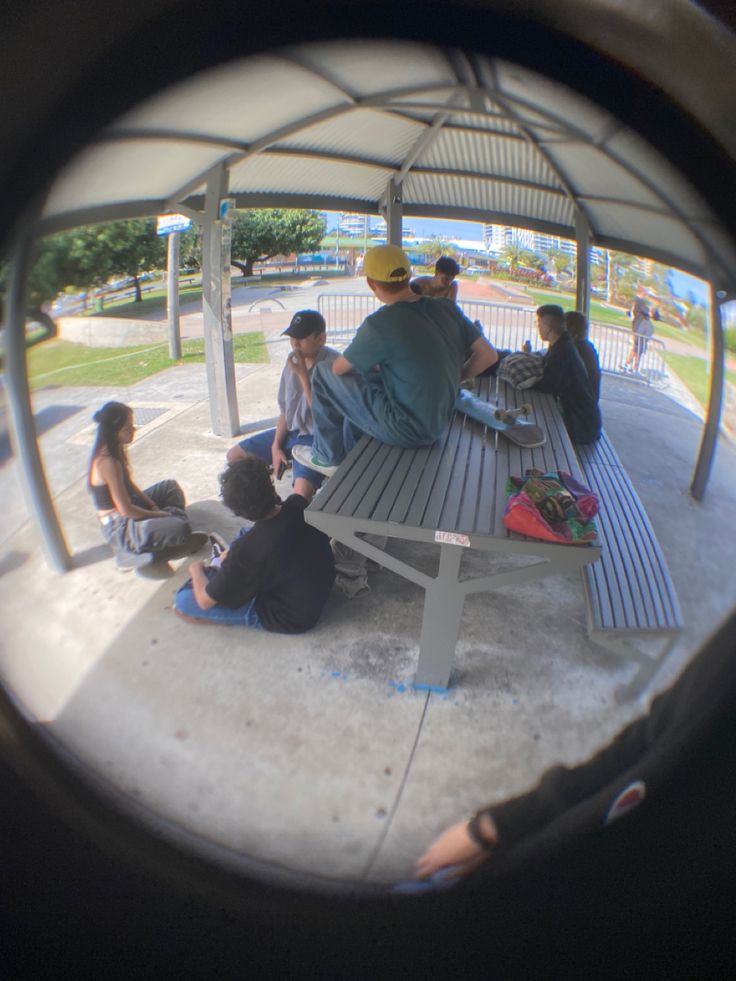 a group of people sitting on top of a wooden bench