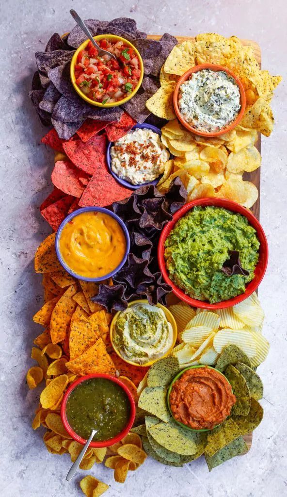 a platter filled with different types of chips and dips on top of each other