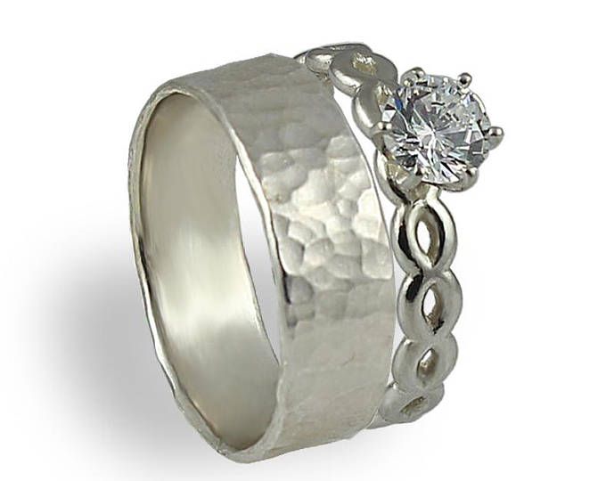 a white gold ring with a diamond in the center and an intricate design on the side