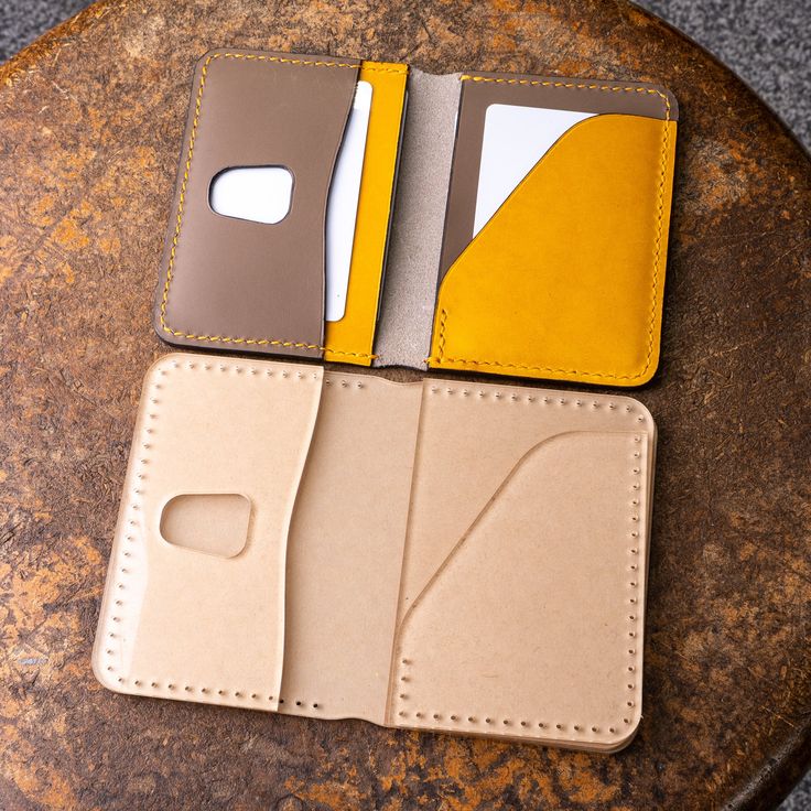 two wallets sitting next to each other on top of a table