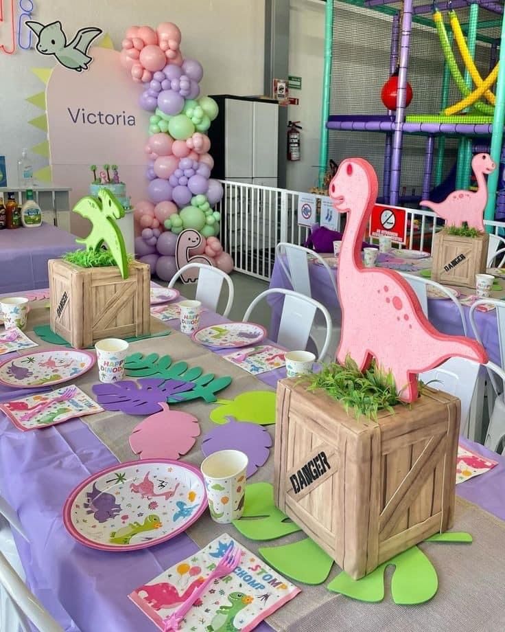 a table set up with plates, napkins and balloons in the shape of animals