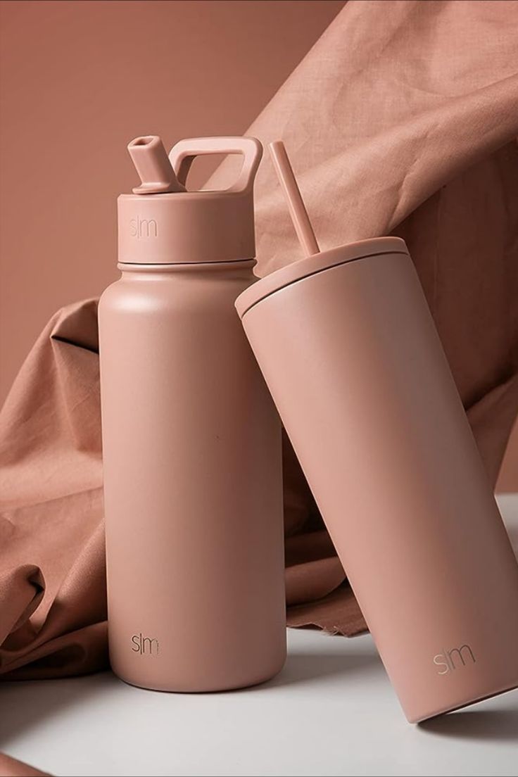 two pink insulated water bottles sitting next to each other