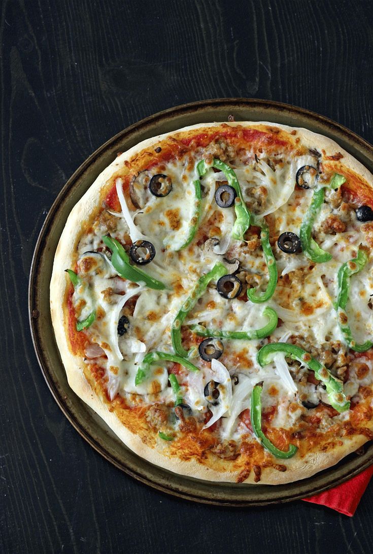 a pizza sitting on top of a pan covered in cheese and veggie toppings