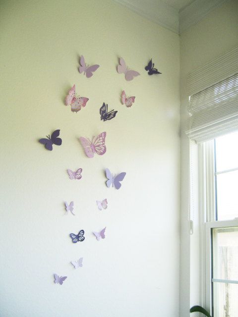 there are many butterflies hanging on the wall in this room, and they look like they have been made out of paper