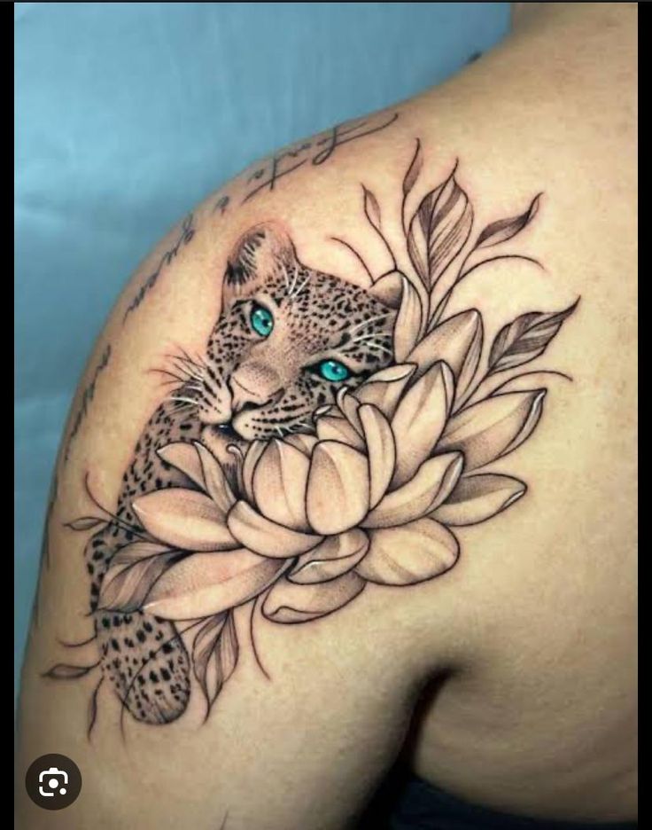 a woman's shoulder with a leopard and flower tattoo on it