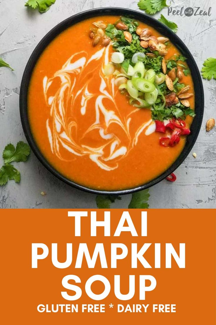 thai pumpkin soup in a black bowl with white sauce and garnishes