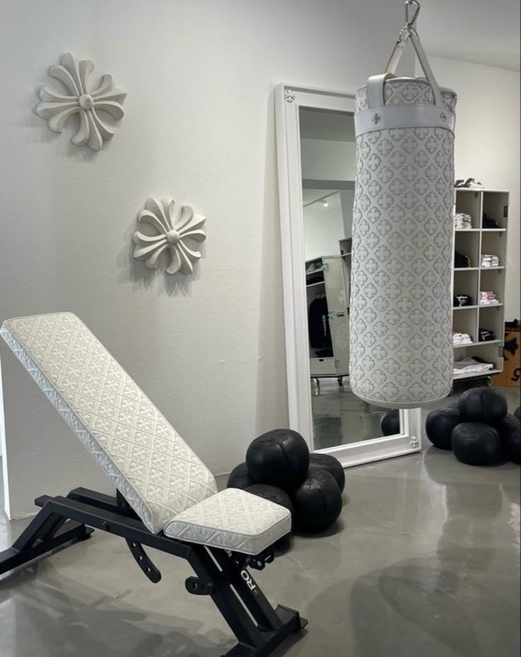 a gym room with black and white balls on the floor, a punching bag hanging from the wall