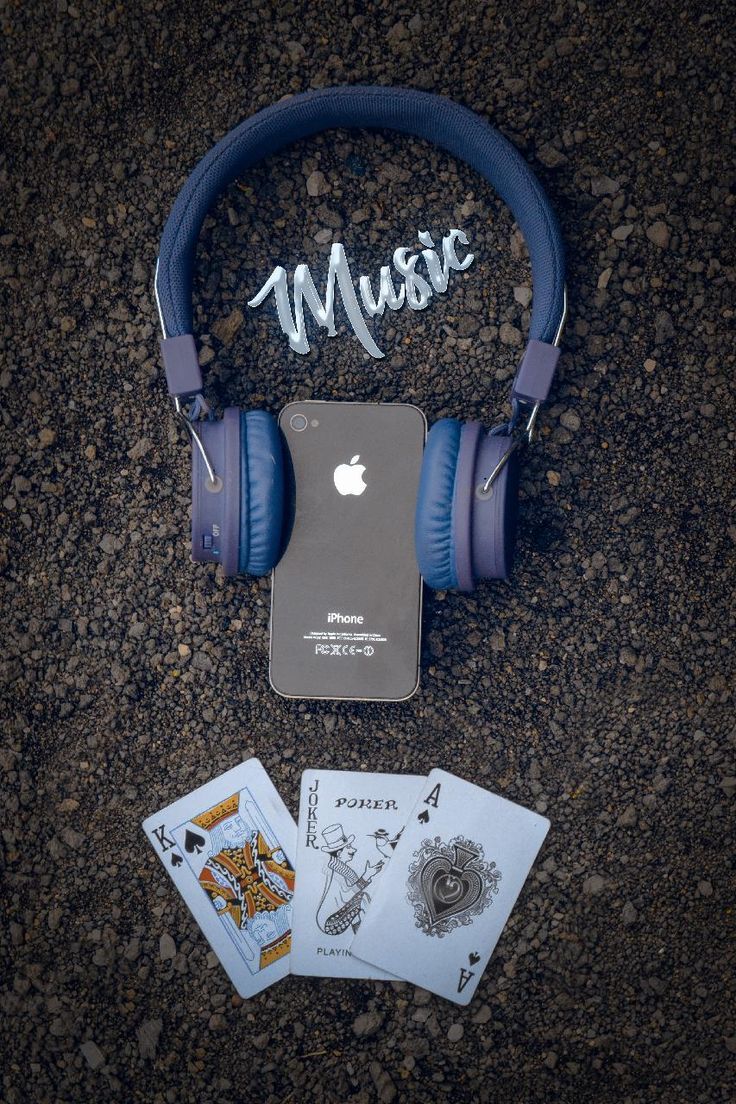 headphones, playing cards and an ipod on the ground with music written on it