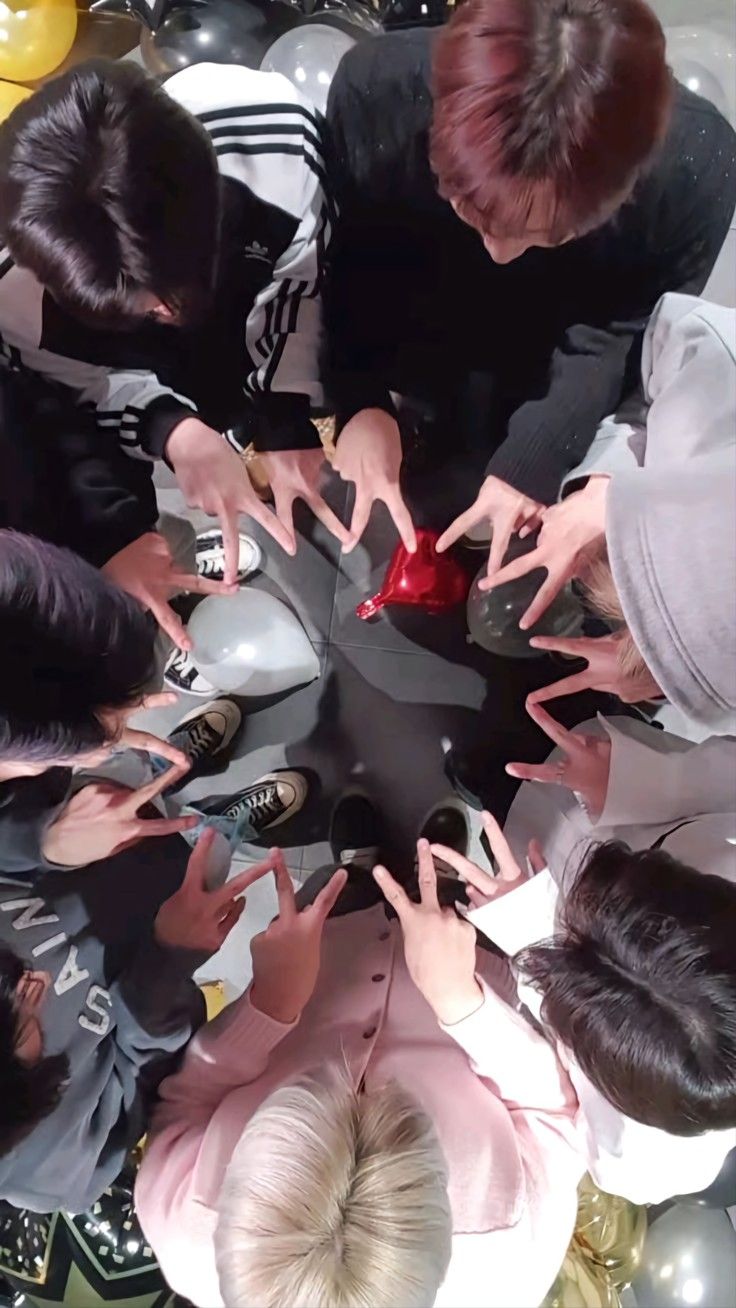 several people standing in a circle with their hands together