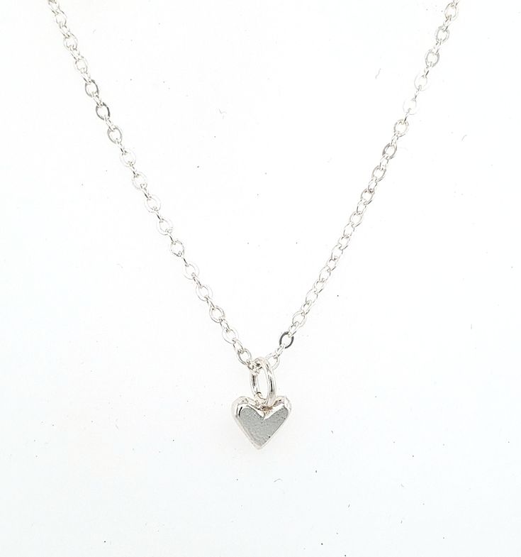 "This is a tiny tiny little heart charm made out of solid sterling silver. It is perfect for layering with other necklaces, or wear it on it's own for a nice and simple necklace. It's perfect for a discrete and minimalist everyday necklace :) The photo on the neck form shows the charm on a 16\" chain, however you can chose between 16\", 18\", or 20\". I make all of my jewelry by hand in my Savannah, GA studio. Please contact me if you have any questions :)" Delicate Tiny Heart Charm Necklaces, Delicate Sterling Silver Charm Necklaces, Minimalist Everyday Charm Necklace With Heart Charm, Delicate Sterling Silver Charm Necklace, Minimalist Everyday Necklace With Heart Charm, Minimalist Everyday Charm Necklace With Heart, Tiny Heart Necklace In Minimalist Style, Minimalist Tiny Heart Pendant Necklaces, Minimalist Heart Charm Jewelry For Everyday