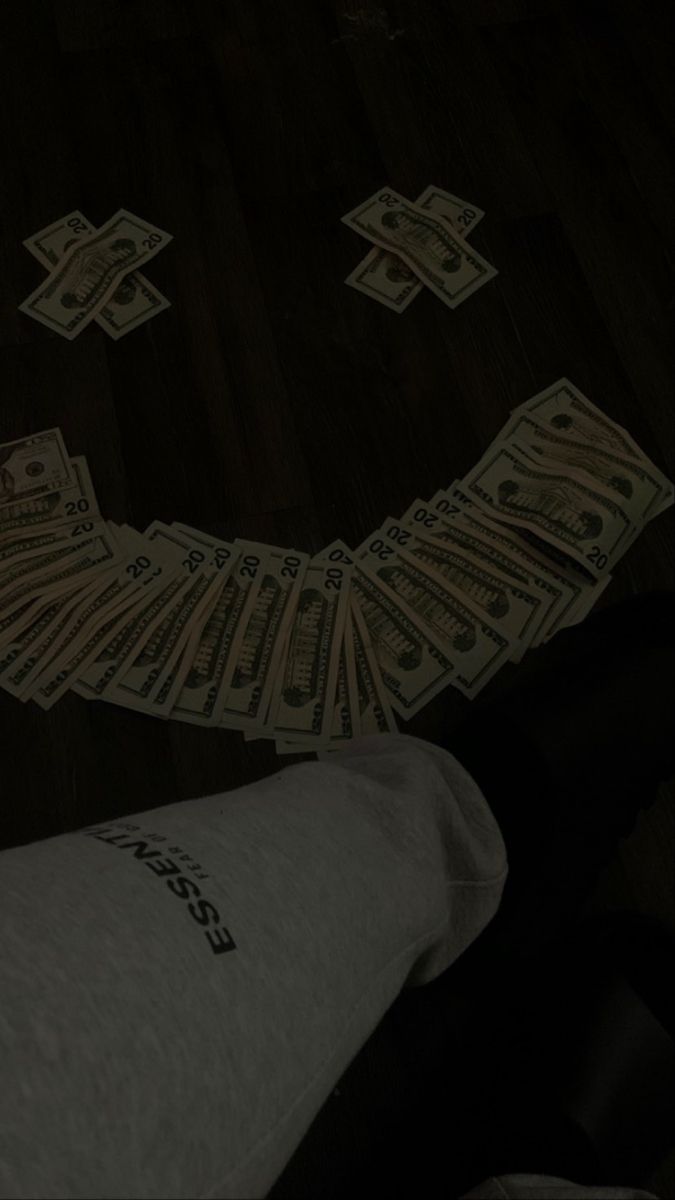 a bunch of money sitting on top of a wooden floor