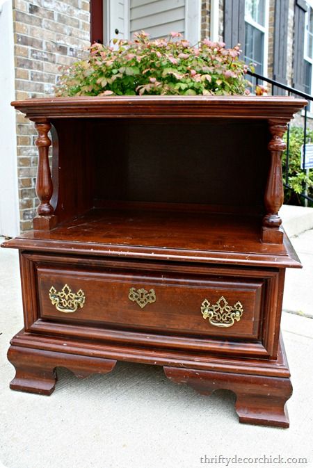 an old wooden dresser with flowers in the top drawer and bottom drawer on it's side