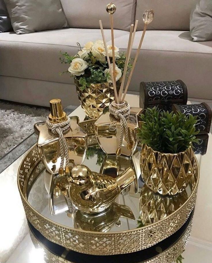 a glass tray with various items on it sitting on a coffee table in front of a couch