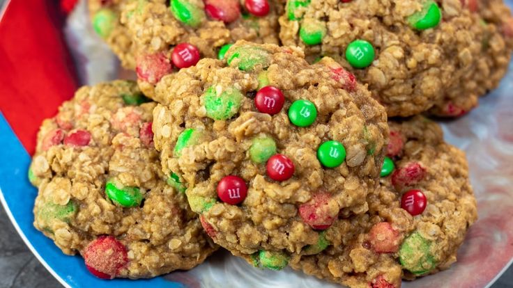 three cookies with m & m on top are stacked next to each other and surrounded by candy