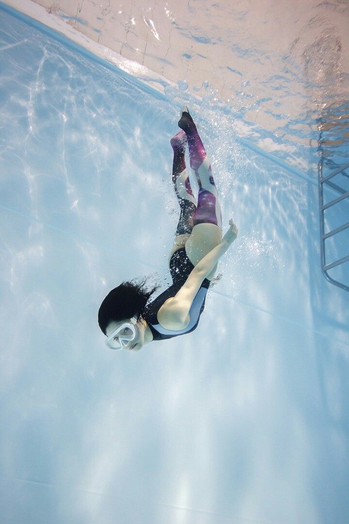 a woman is swimming in the pool