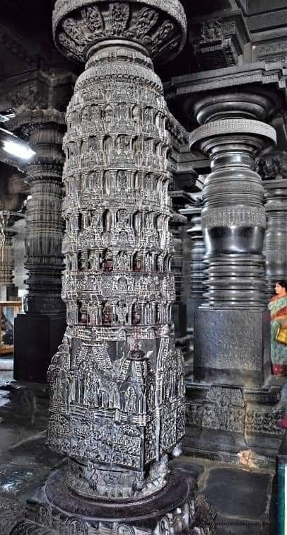 an intricately carved pillar in the middle of a building