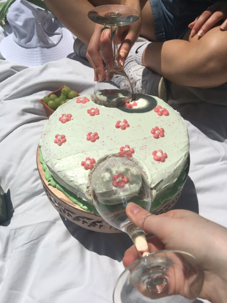 two people toasting wine glasses over a cake