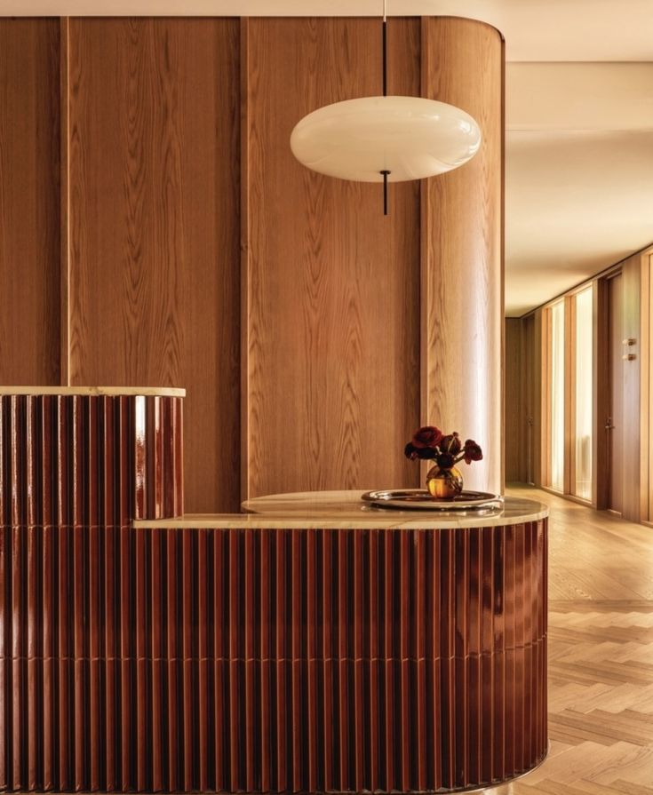 a room with wood paneling and a round light hanging from the ceiling above it