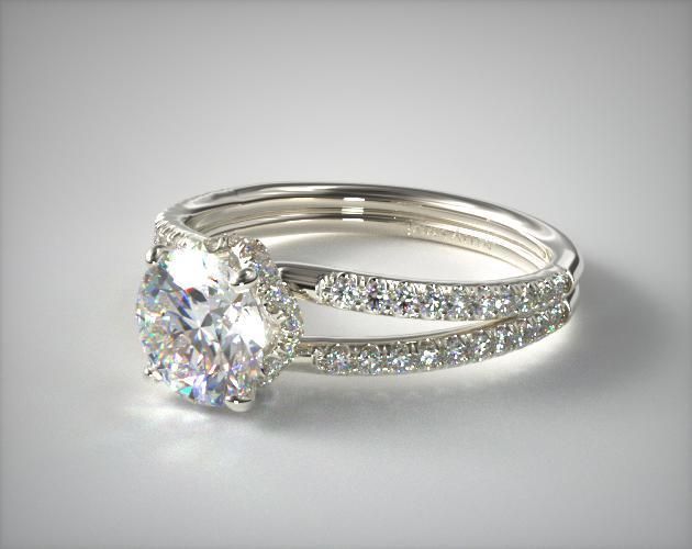 an engagement ring set with a round cut diamond in the center and side stones on each band