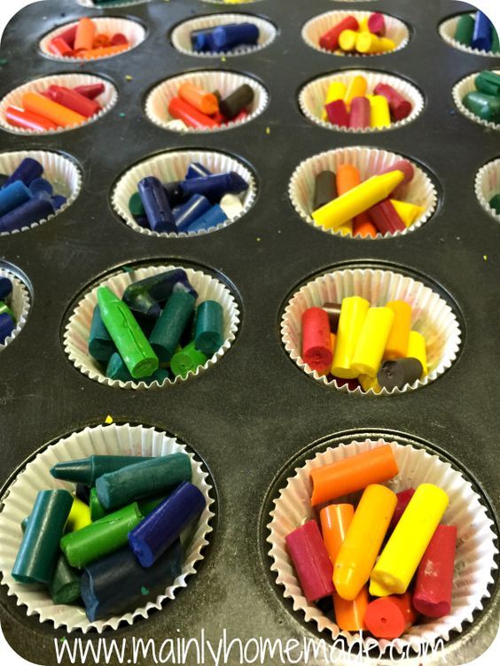 cupcake tins filled with colored crayons on top of a baking tray