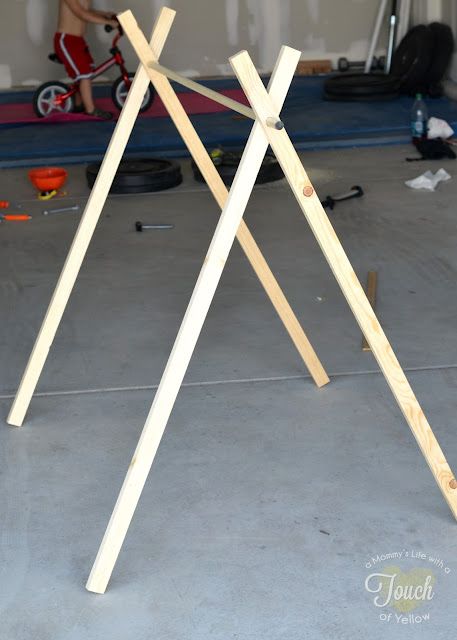 a couple of wooden poles sitting on top of a garage floor next to a child's tricycle