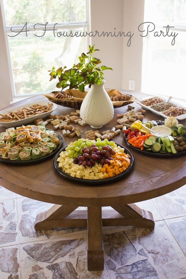 a wooden table topped with lots of plates filled with different types of foods and vegetables