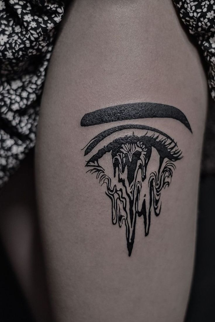 a close up of a person's leg with a tattoo on the thigh and an eye