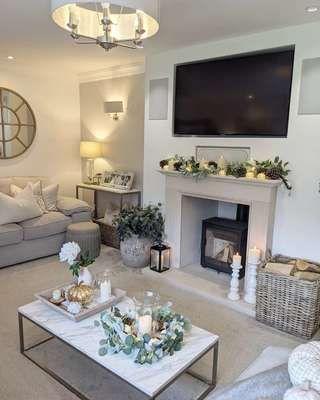 a living room filled with furniture and a flat screen tv mounted on the wall above a fireplace